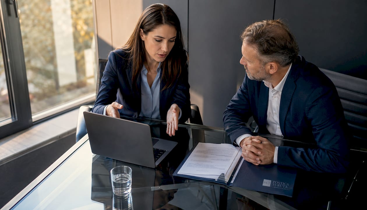 Avocatul oferă consultanță unui client într-un birou, discutând împreună detaliile unui caz sau clarificând aspecte juridice.